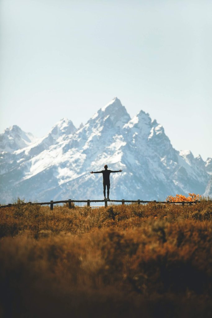 person standing on a fence with open arms